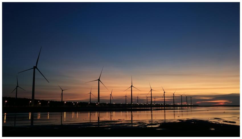 Serene view of wind turbines reflecting on water a