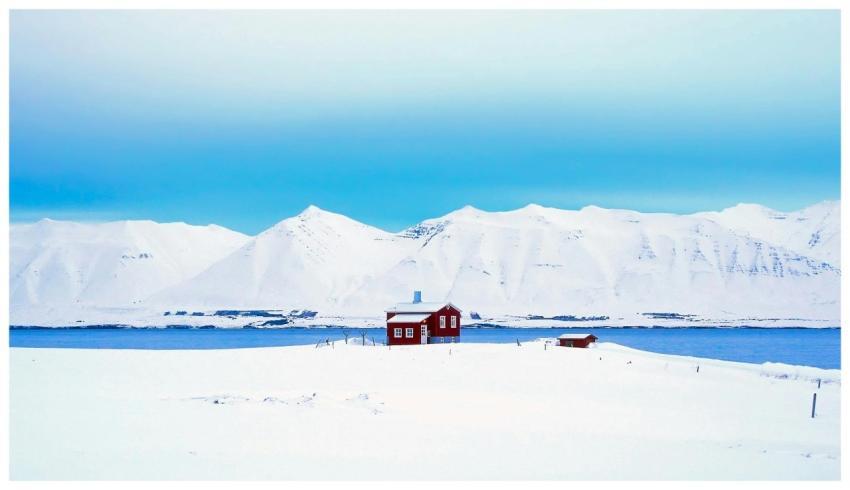 A solitary red cabin amidst a vast snowy landscape