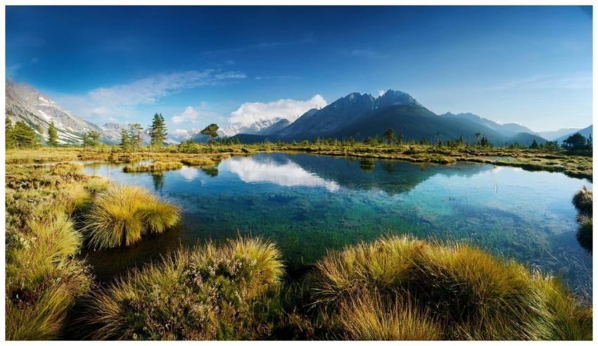 A scenic mountain lake with clear reflections unde