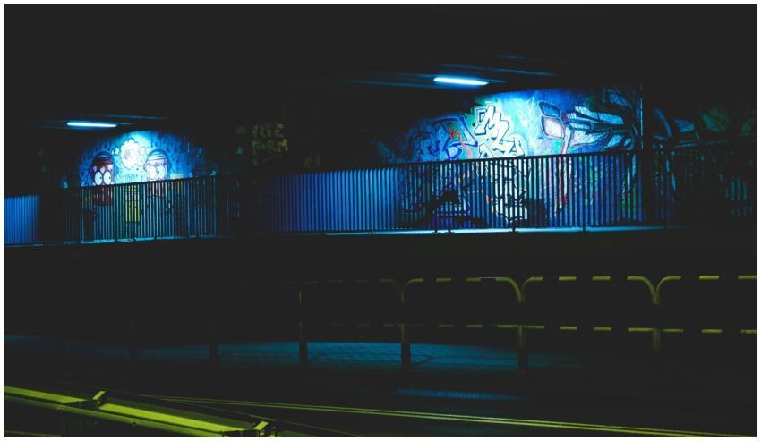 Illuminated urban graffiti under a bridge at night