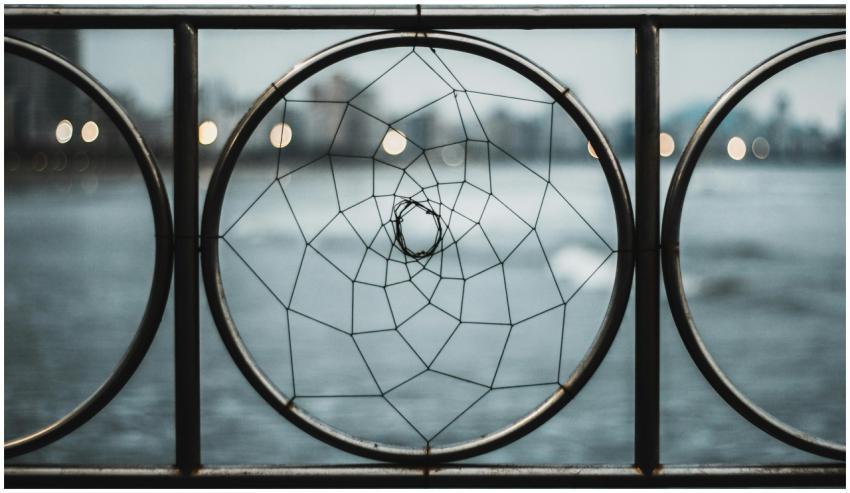 A close-up of an iron railing featuring a circular