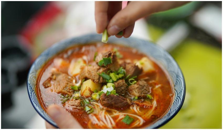 Delicious spicy beef noodle soup garnished with fr
