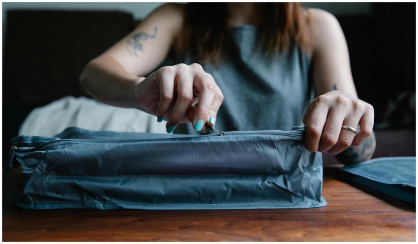 Close-up of a woman with manicured nails zipping a