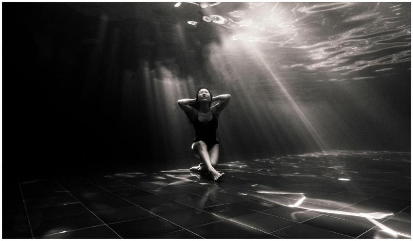 Black and white underwater shot of a woman in a pe