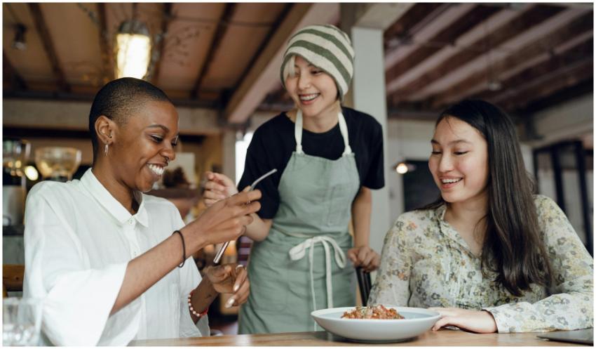 Group of friends laughing and eating together in a