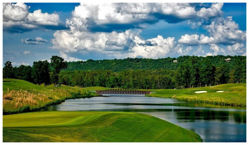 Scenic golf course with lush greenery, river, and