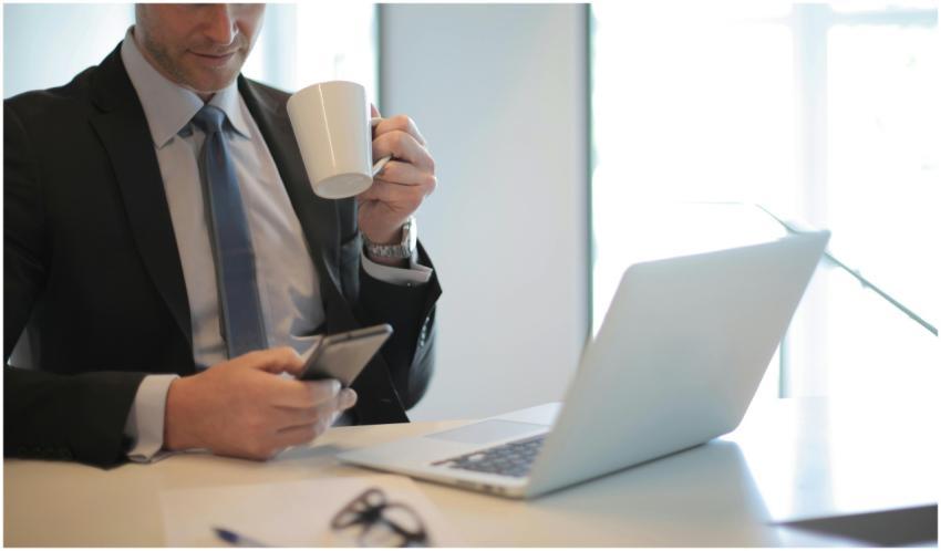 Professional businessman using smartphone while ho