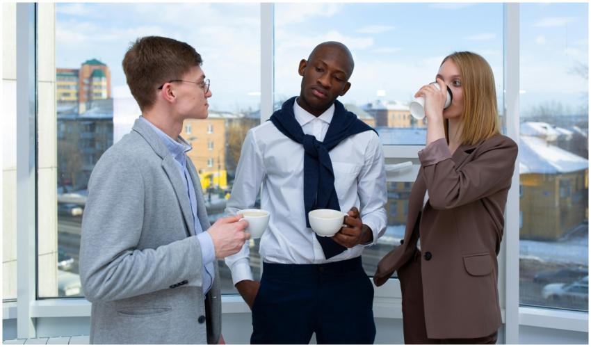 Three diverse colleagues take a coffee break, show
