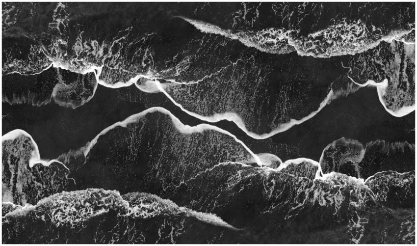 Stunning monochrome aerial shot of ocean waves cra