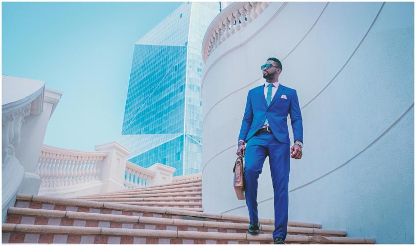 Stylish businessman walking up stairs with skyscra