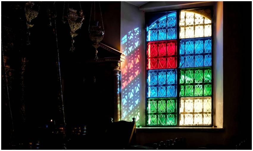 Colorful stained glass window casting vibrant shad