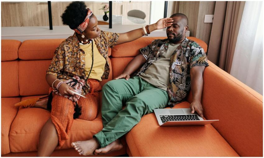 A concerned woman checks her partner's temperature