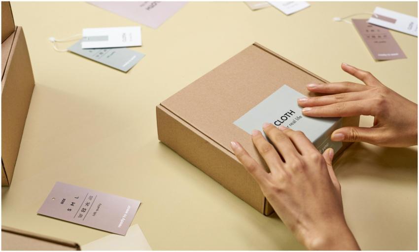 Hands carefully packing a cardboard box with multi