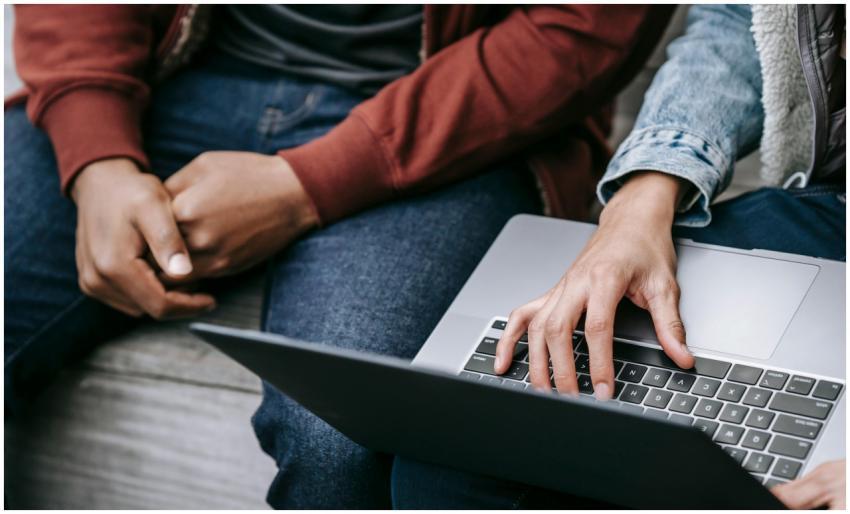 Close-up of two people working together on a lapto
