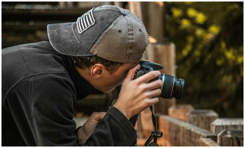 Close-up of a young male photographer taking photo