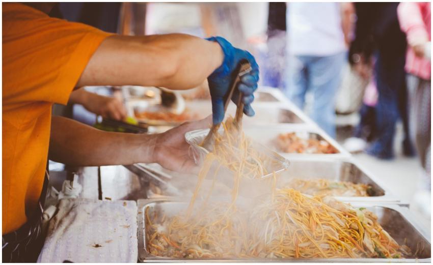 A street vendor serving freshly cooked noodles at
