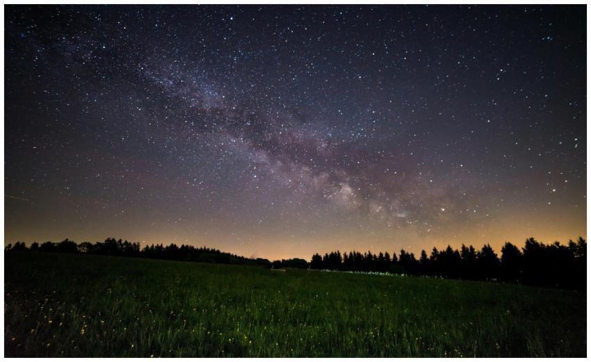 A breathtaking view of a starry night sky over a q
