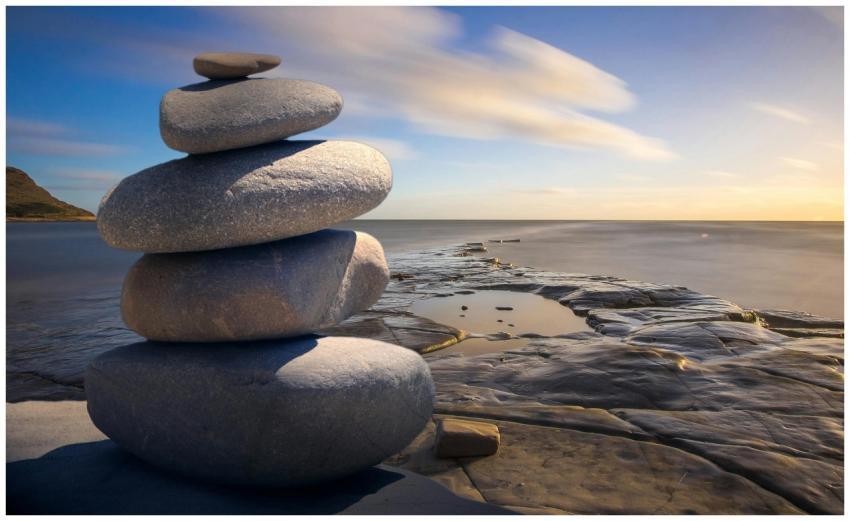 A serene stack of stones on the rocky seashore dur