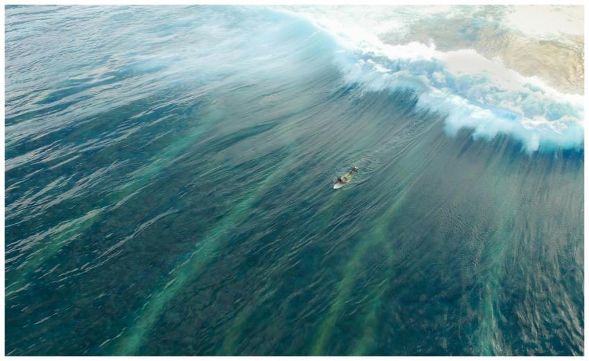 Breathtaking aerial shot of a surfer navigating th