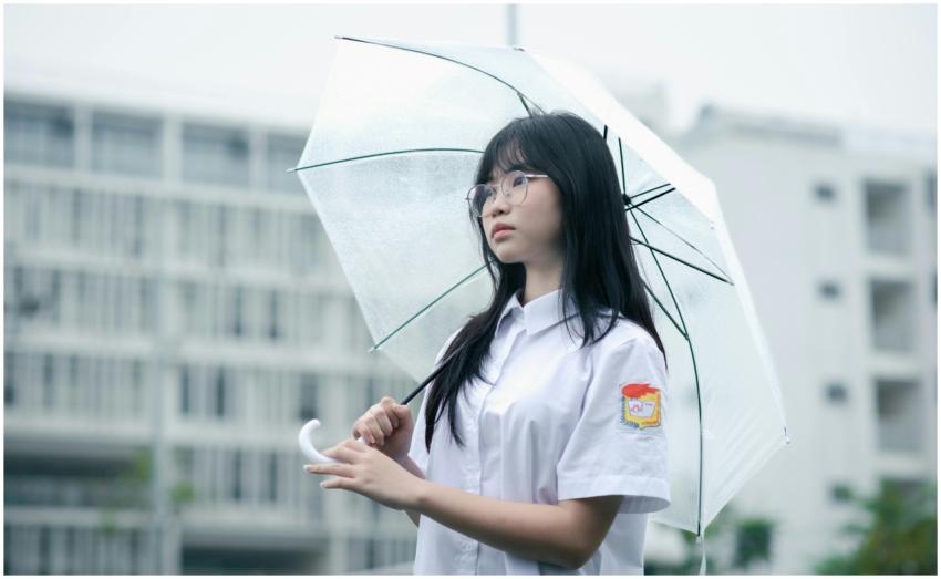 A young woman in a school uniform holding a transp