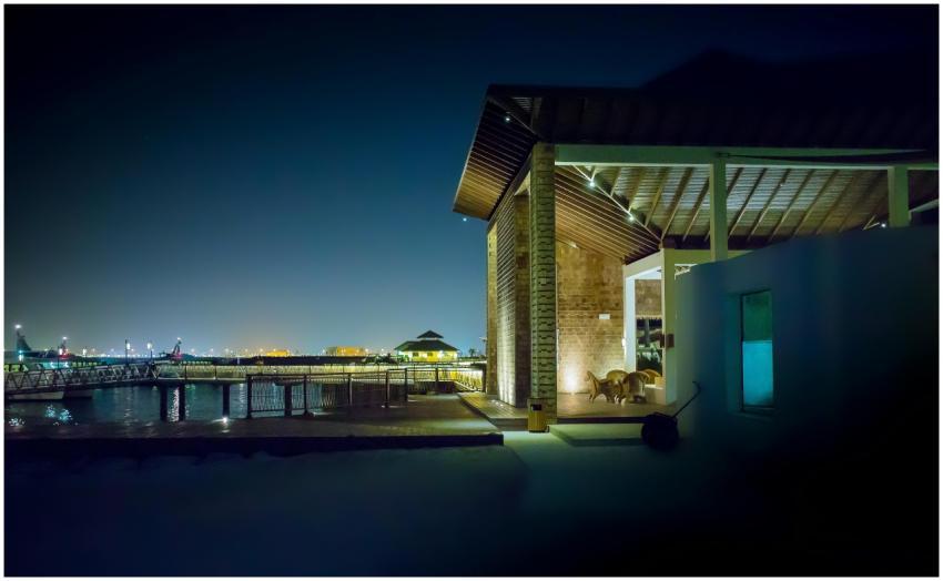 A modern waterfront house illuminated at night, fe