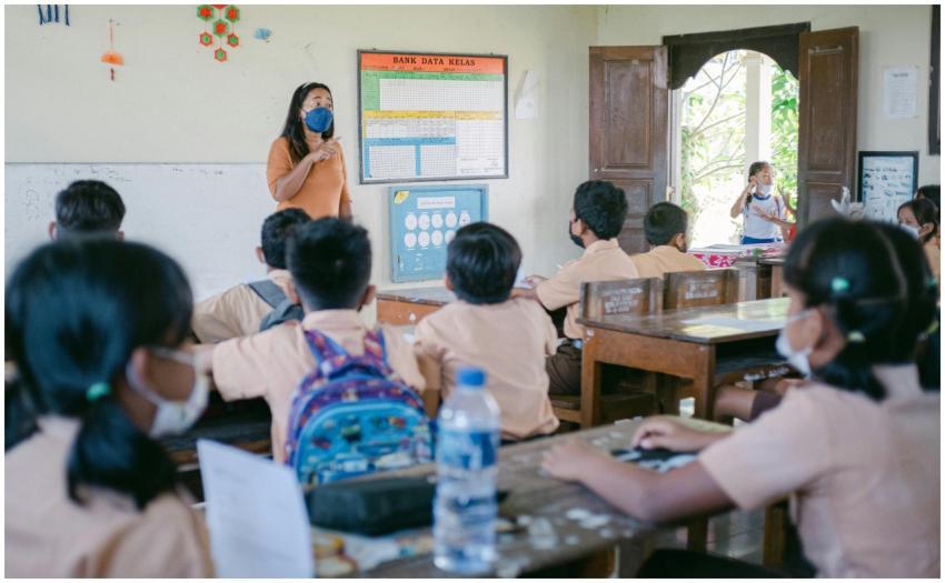 A classroom scene with students and a teacher wear