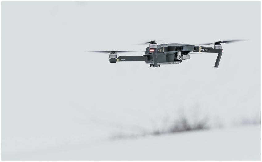 A modern drone flying over a serene, snow-covered