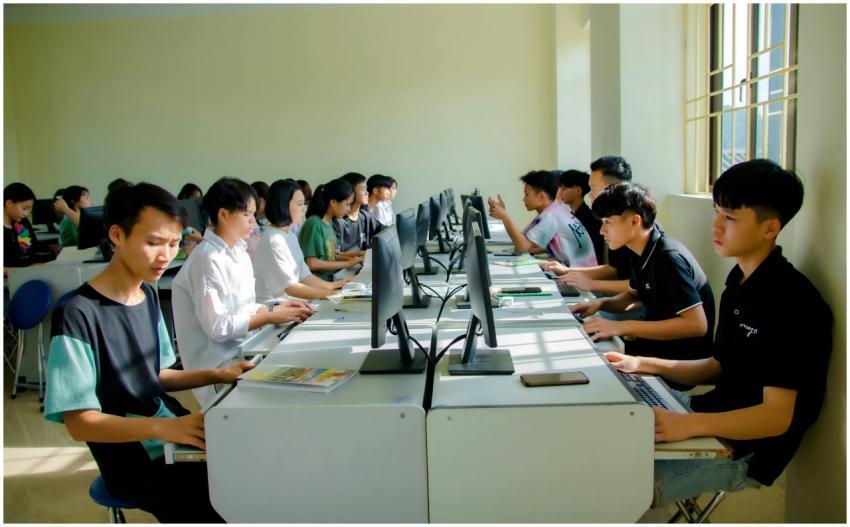 A group of students focused on computer tasks in a