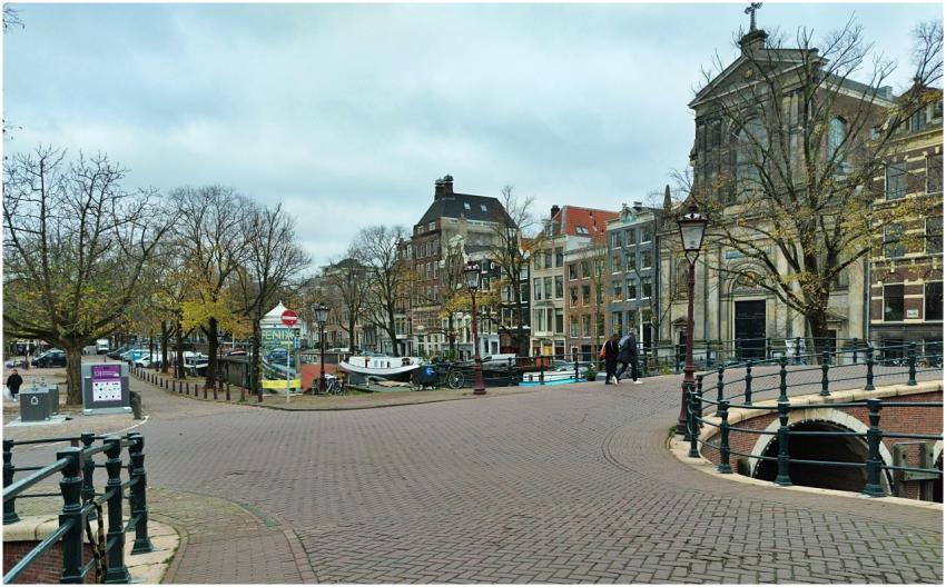 An empty cobblestone canal bridge in Amsterdam wit