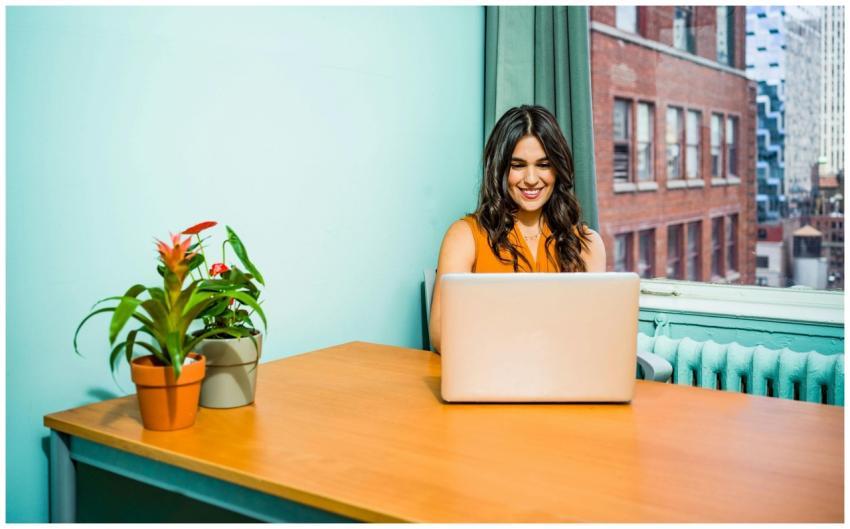 Confident woman in a bright office working on a la