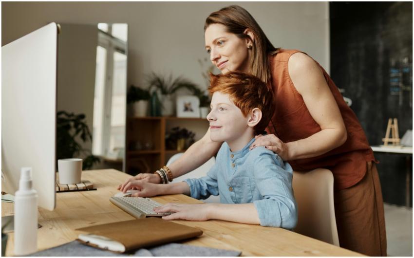 A mother and her child smiling while using a compu