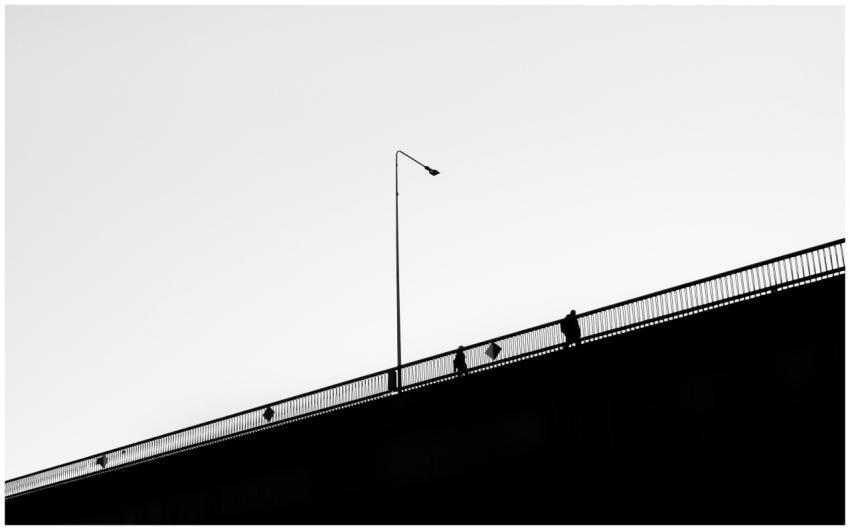 Black and white photo of people silhouetted on a b