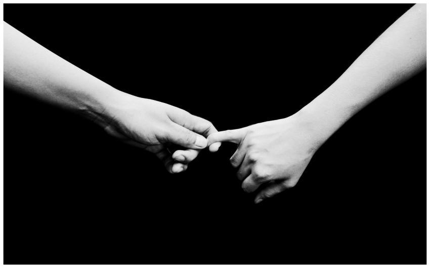 Two hands reaching out in a black and white compos
