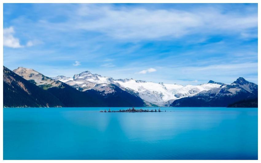 A stunning view of a serene mountain lake with sno