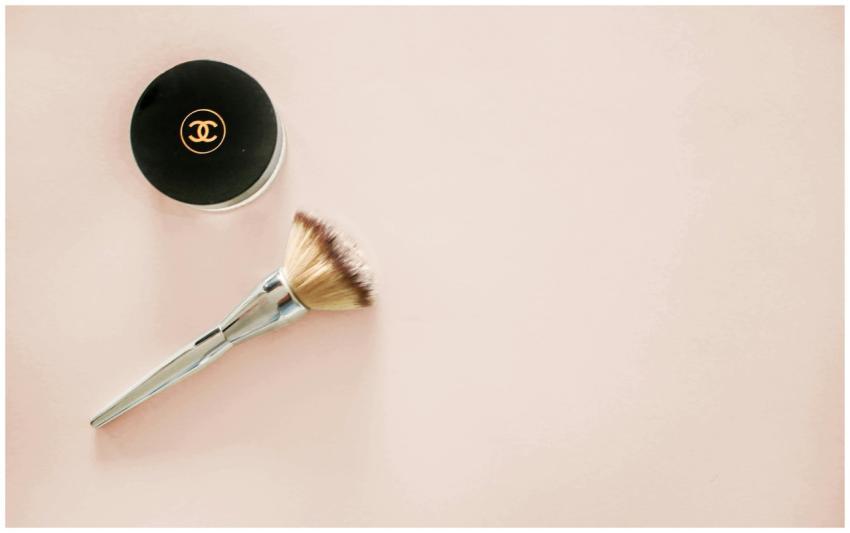 Sophisticated flatlay of a makeup brush and brande