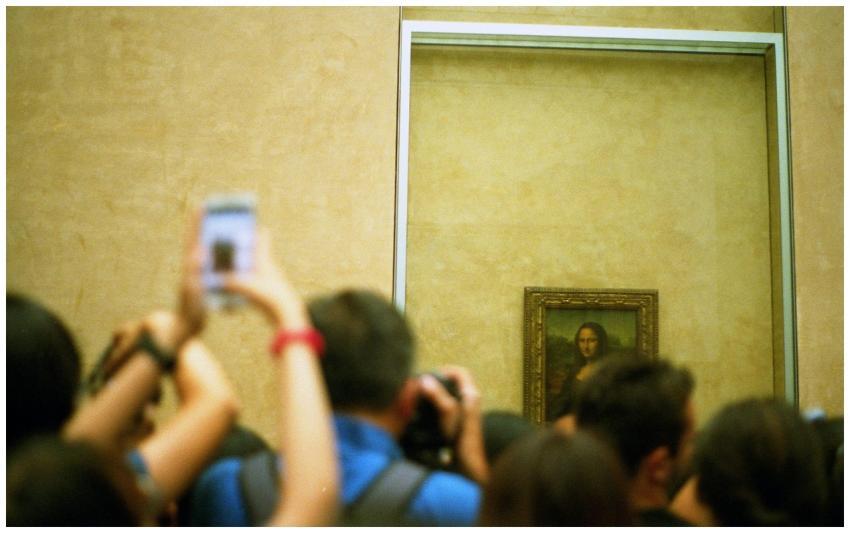 Visitors in the Louvre Museum capturing the iconic