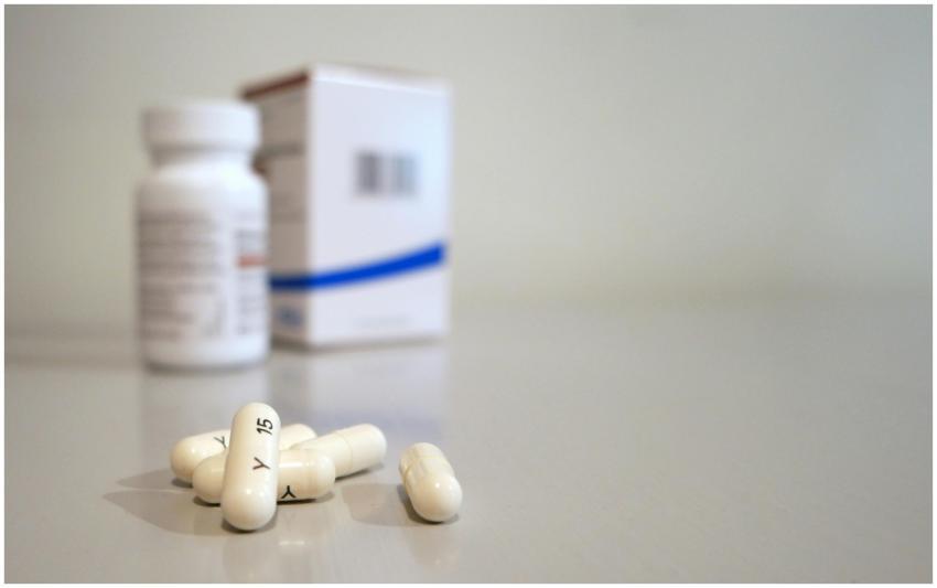 Close-up image of white capsules with medicine bot