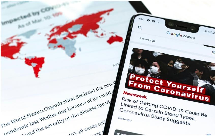 Smartphone with coronavirus updates and world map