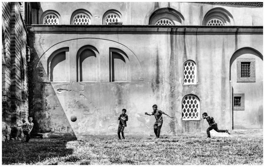 Black and white photo of kids playing football out