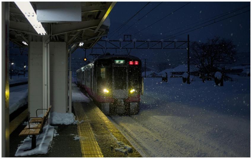 Train entering Imajo station during a winter night