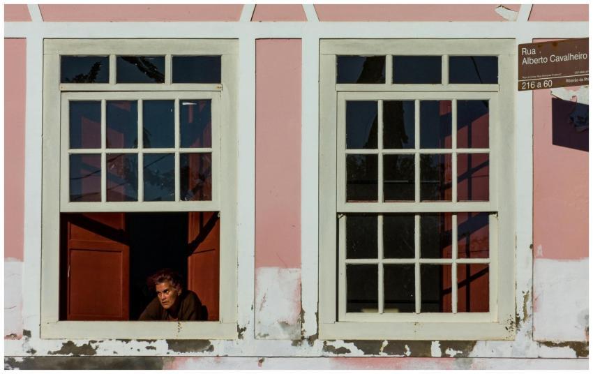 A person looking out from a vintage window in a su