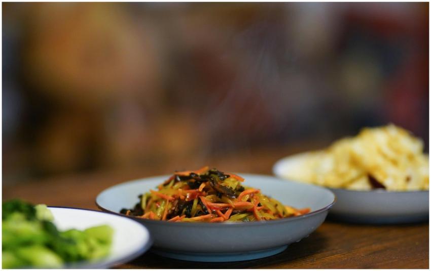 A close-up of steaming stir-fried vegetables, broc
