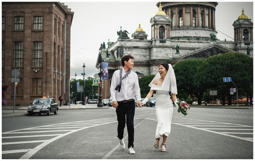 Bride and groom joyfully walk near St. Isaac's Cat