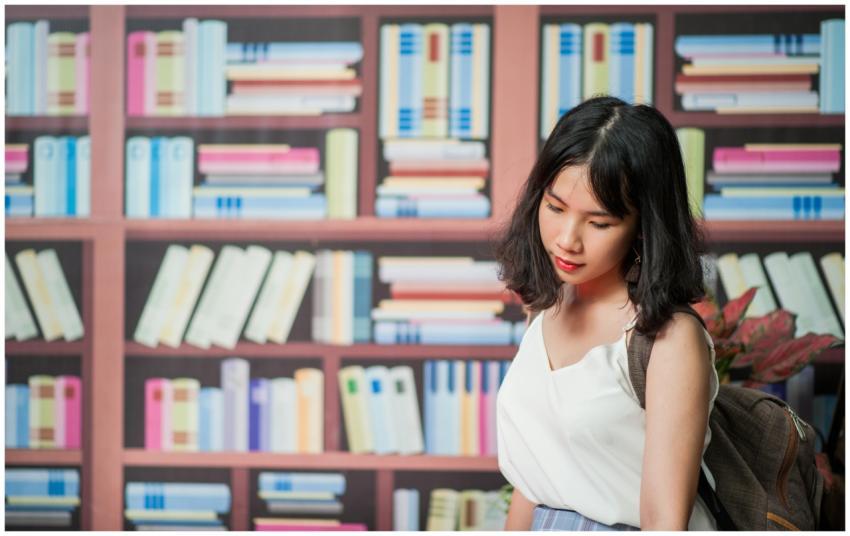 A young woman with a backpack is standing in front