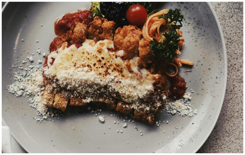 Crispy chicken parmigiana topped with cheese and t
