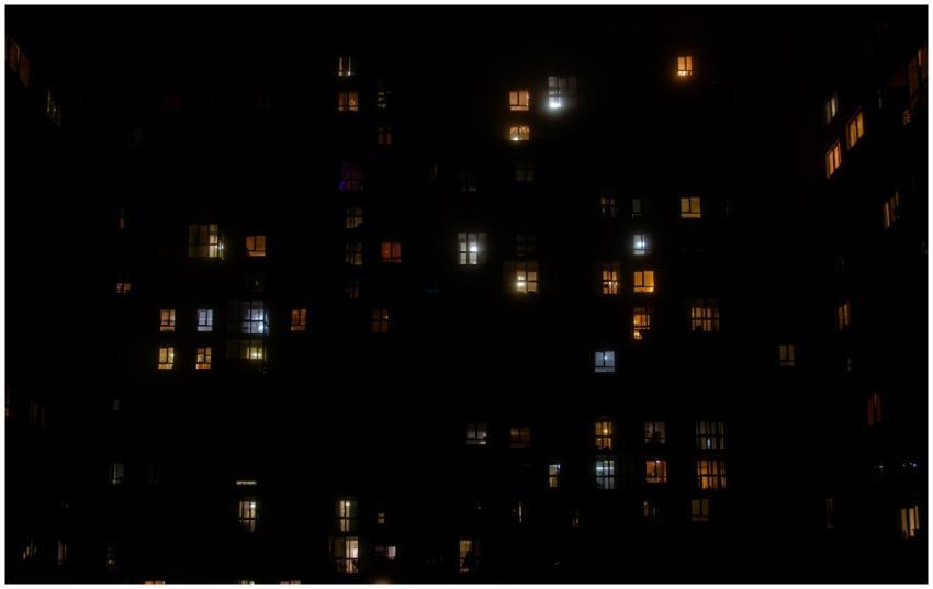 A cityscape view of brightly lit apartment windows