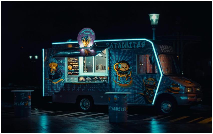 Colorful food truck glowing with neon lights durin