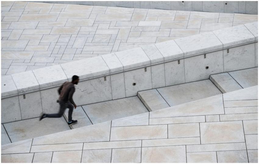 Dynamic shot of a man running up modern urban step