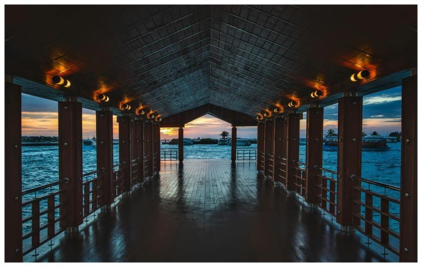A wooden pier with illuminated lights overlooking