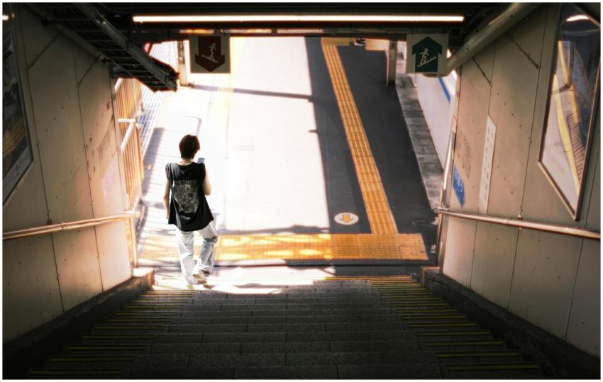 A person descending stairs at a Tokyo station, sho